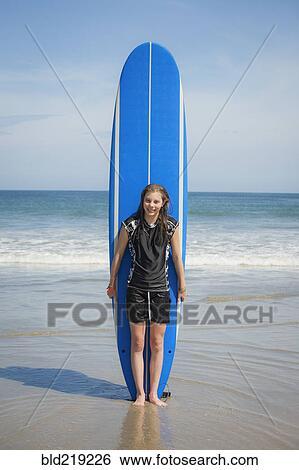 Caucasian girl holding paddleboard on beach View Large Photo Image Stock Photograph - Caucasian girl holding paddleboard on beach. Fotosearch