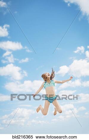 Caucasian girl jumping for joy in blue sky View Large Photo Image Stock Photography - Caucasian girl jumping for joy in blue sky. Fotosearch