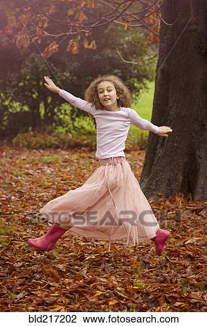 Caucasian girl jumping for joy in autumn leaves View Large Photo Image Stock Image - Caucasian girl jumping for joy in autumn leaves. Fotosearch