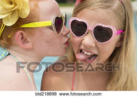 Caucasian girl kissing cheek of friend near swimming pool View Large Photo Image Stock Photo - Caucasian girl kissing cheek of friend near swimming pool. Fotosearch