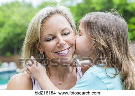 Caucasian girl kissing mother in backyard View Large Photo Image Picture - Caucasian girl kissing mother in backyard. Fotosearch