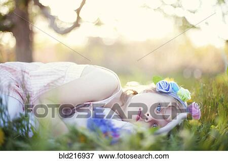 Stock Photo - Caucasian girl laying in grass. Fotosearch