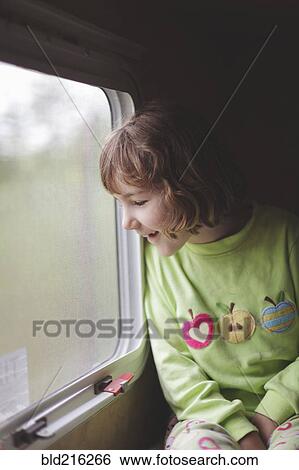 Stock Photograph - Caucasian girl looking out train window. Fotosearch