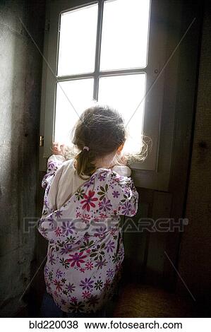 Stock Photo - Caucasian girl looking out window. Fotosearch