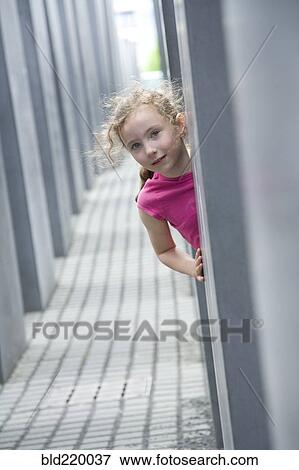 Caucasian girl peeking around corner in hallway View Large Photo Image Stock Photo - Caucasian girl peeking around corner in hallway. Fotosearch
