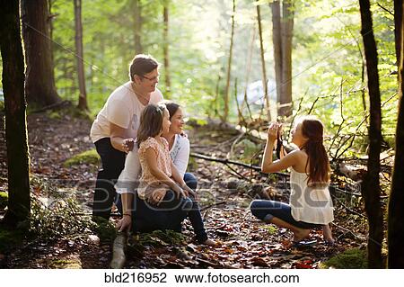 Caucasian girl photographing family in forest View Large Photo Image Stock Image - Caucasian girl photographing family in forest. Fotosearch