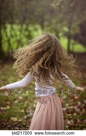Stock Image - Caucasian girl playing in autumn leaves. Fotosearch
