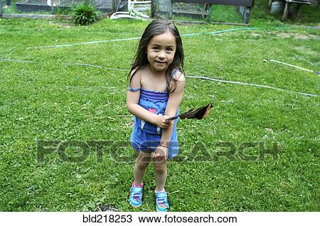 Stock Image - Caucasian girl playing in backyard. Fotosearch