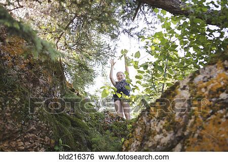 Stock Photograph - Caucasian girl playing in forest. Fotosearch