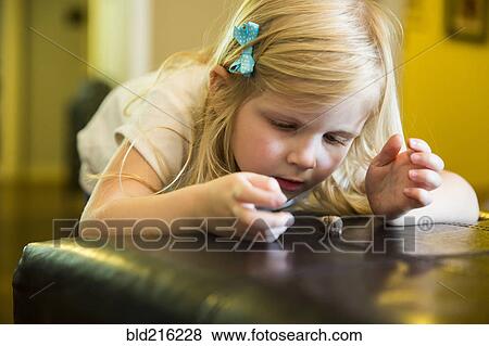 Caucasian girl playing with snail on ottoman View Large Photo Image Stock Photo - Caucasian girl playing with snail on ottoman. Fotosearch