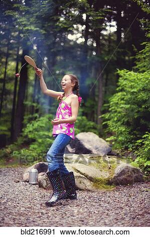 Stock Image - Caucasian girl playing with toy in forest. Fotosearch
