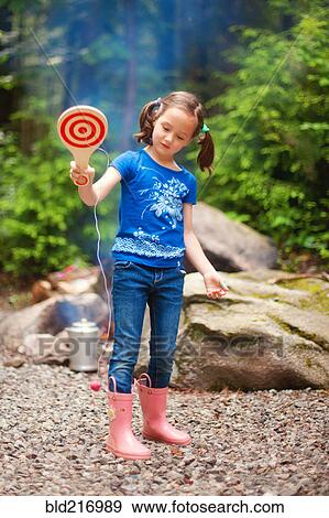 Caucasian girl playing with toy in forest View Large Photo Image Stock Photo - Caucasian girl playing with toy in forest. Fotosearch