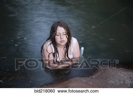 Stock Image - Caucasian girl shivering in lake. Fotosearch
