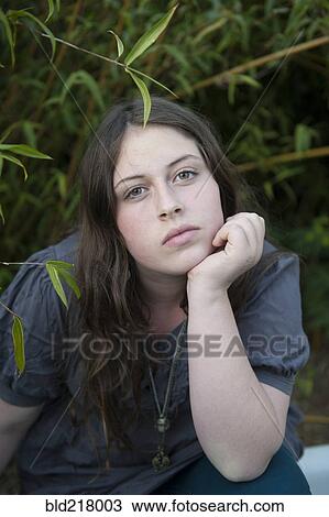 Stock Image - Caucasian girl sitting in branches. Fotosearch