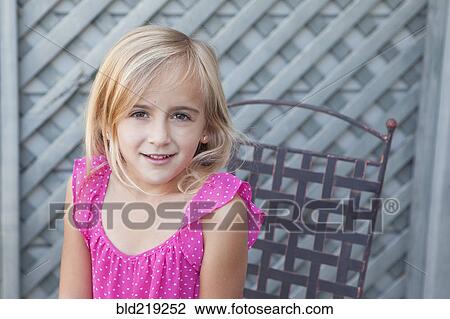 Stock Image - Caucasian girl sitting in chair. Fotosearch