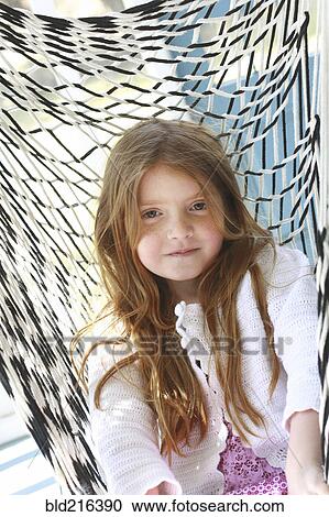 Stock Image - Caucasian girl sitting in hammock. Fotosearch
