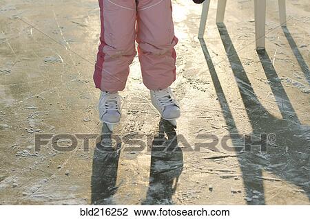 Stock Image - Caucasian girl skating on frozen ice. Fotosearch