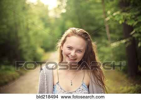 Picture - Caucasian girl smiling on forest path. Fotosearch