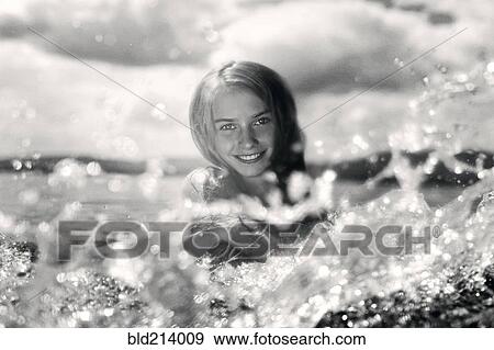 Stock Photo - Caucasian girl splashing in lake. Fotosearch