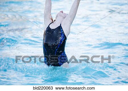 Stock Image - Caucasian girl splashing in swimming pool. Fotosearch