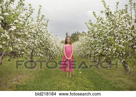 Caucasian girl standing in blooming orchard View Large Photo Image Picture - Caucasian girl standing in blooming orchard. Fotosearch