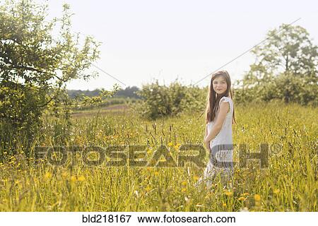Stock Photo - Caucasian girl standing in rural field. Fotosearch