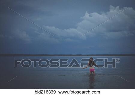 Caucasian girl wading in remote lake View Large Photo Image Stock Photo - Caucasian girl wading in remote lake. Fotosearch