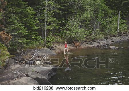 Stock Photo - Caucasian girl walking in remote river. Fotosearch
