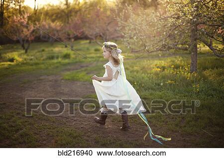 Stock Image - Caucasian girl walking on dirt path. Fotosearch