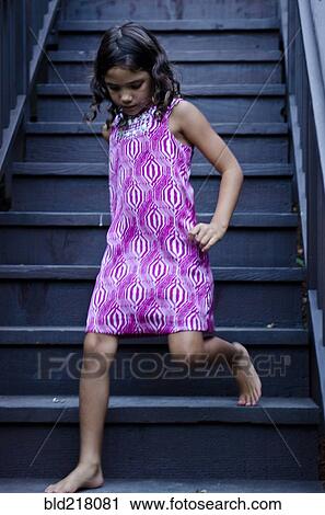 Stock Image - Caucasian girl walking on steps. Fotosearch