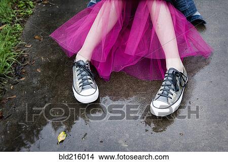 Picture - Caucasian girl wearing sneakers and tutu in puddle. Fotosearch