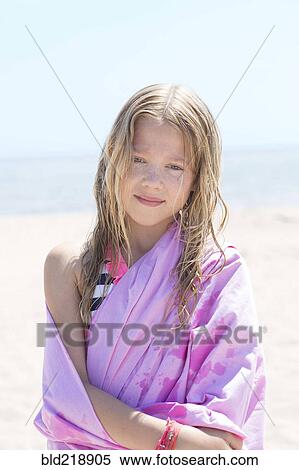 Stock Photography - Caucasian girl wrapped in towel on beach. Fotosearch