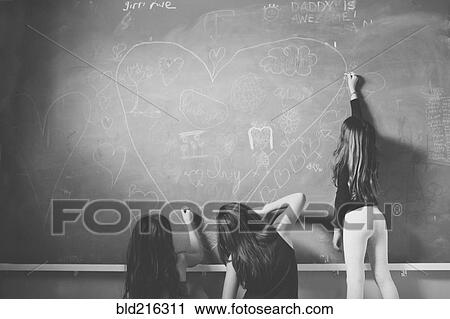 Caucasian girls drawing on classroom chalkboard View Large Photo Image Stock Image - Caucasian girls drawing on classroom chalkboard. Fotosearch