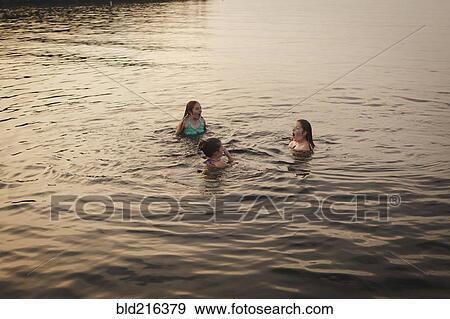 Stock Photo - Caucasian girls swimming in lake. Fotosearch