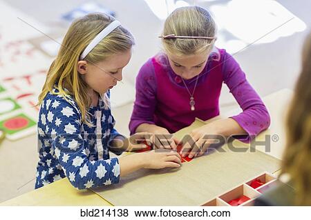 Stock Photo - Caucasian girls working together in classroom. Fotosearch