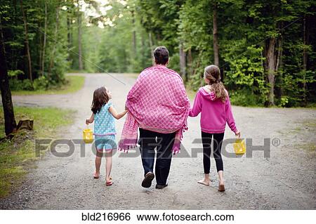 Stock Photograph - Caucasian grandmother and granddaughters on rural road. Fotosearch