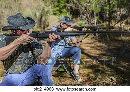 Caucasian hunters aiming guns in forest View Large Photo Image Stock Image - Caucasian hunters aiming guns in forest. Fotosearch