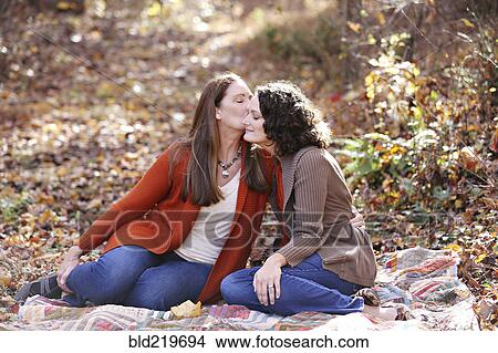 Caucasian lesbian kissing cheek of girlfriend in autumn leaves View Large Photo Image Picture - Caucasian lesbian kissing cheek of girlfriend in autumn leaves. Fotosearch