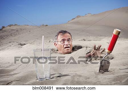 Caucasian man buried in sand next to glass of water and trowel View Large Photo Image Stock Image - Caucasian man buried in sand next to glass of water and trowel. Fotosearch