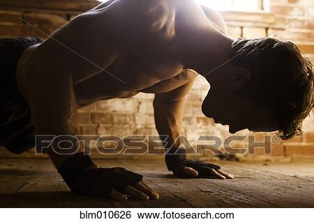 Stock Photograph - Caucasian man doing push-ups. Fotosearch