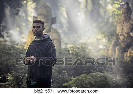 Caucasian man exploring ancient statues in forest View Large Photo Image Stock Image - Caucasian man exploring ancient statues in forest. Fotosearch