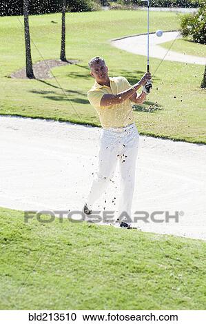 Caucasian man golfing from sand trap on golf course View Large Photo Image Stock Image - Caucasian man golfing from sand trap on golf course. Fotosearch