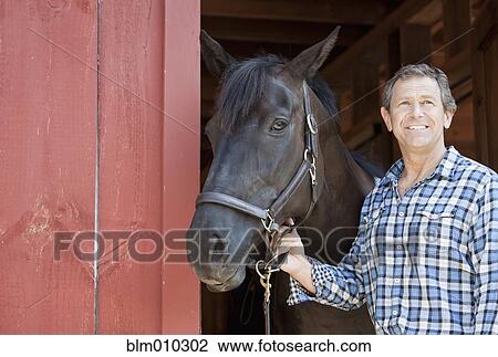 Caucasian man holding horse's bridle View Large Photo Image Stock Image - Caucasian man holding horse's bridle. Fotosearch