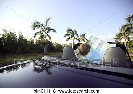 Caucasian man in convertible looking at map View Large Photo Image Stock Photo - Caucasian man in convertible looking at map. Fotosearch