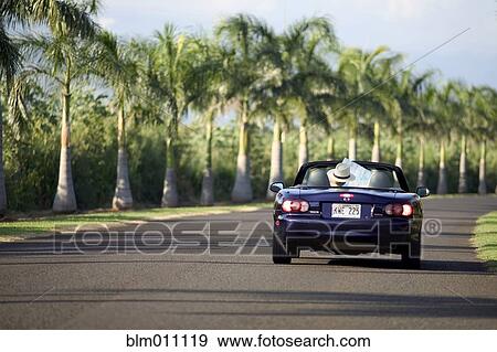 Stock Photo - Caucasian man in convertible looking at map. Fotosearch