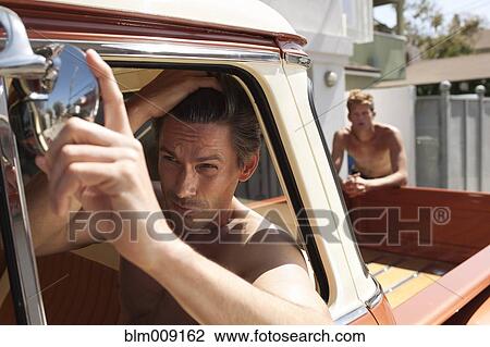 Caucasian man in truck fixing hair View Large Photo Image Stock Image - Caucasian man in truck fixing hair. Fotosearch