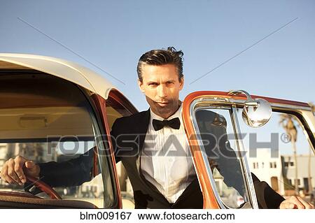 Caucasian man in tuxedo getting into car View Large Photo Image Stock Photo - Caucasian man in tuxedo getting into car. Fotosearch