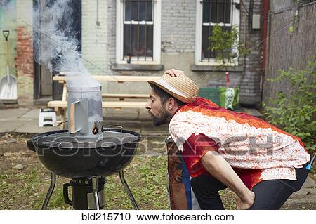 Caucasian man lighting charcoal for grill in backyard View Large Photo Image Stock Image - Caucasian man lighting charcoal for grill in backyard. Fotosearch