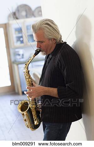 Stock Image - Caucasian man playing saxophone. Fotosearch