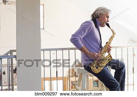 Stock Photo - Caucasian man playing saxophone. Fotosearch